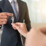 Hand of woman taking keys from hand of real estate owner