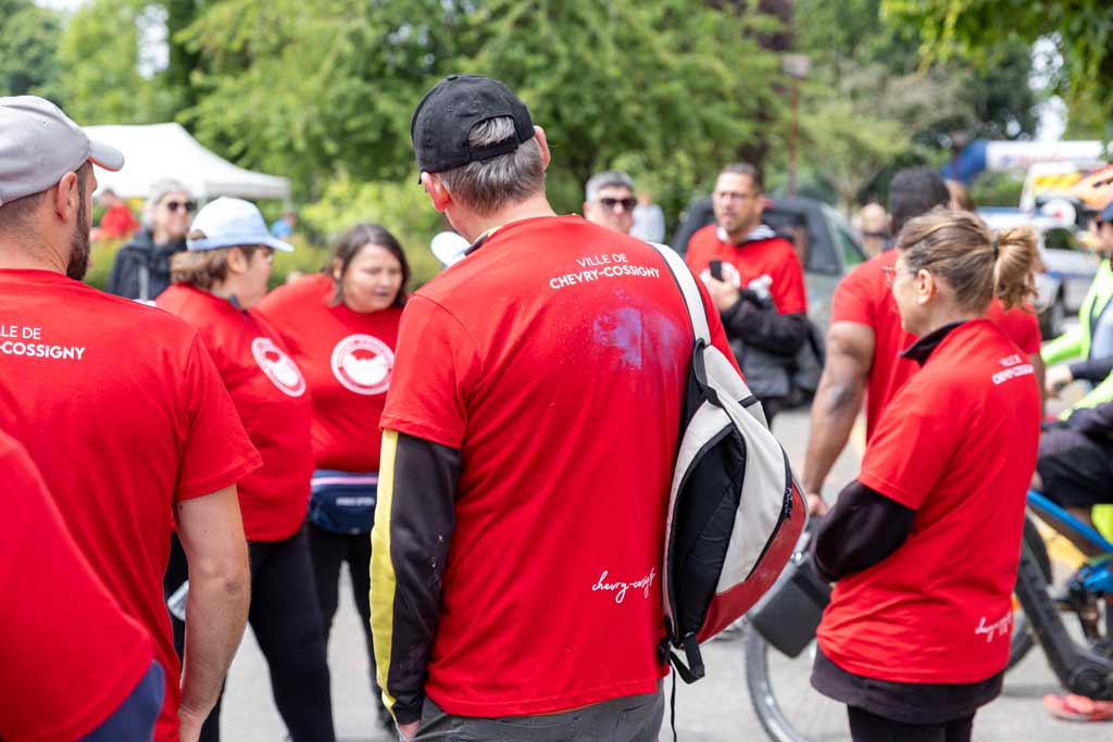 Bénévoles de Chevry-Cossigny rassemblés sur une place, reconnaissable à tee-shirt rouge avec inscrit dans le dos "ville de Chevry-Cossigny"
